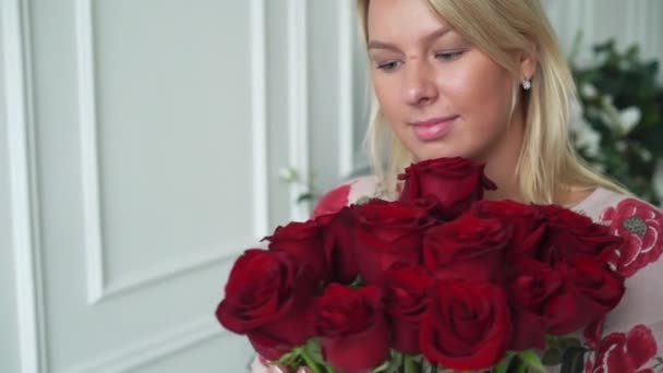 Mujer joven con ramo de rosas rojas — Vídeo de stock