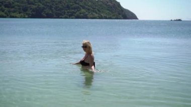 Genç kadın bir denizde siyah Bikini