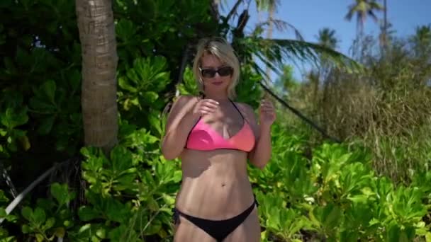 Tânără femeie în costume de baie roz la plajă — Videoclip de stoc