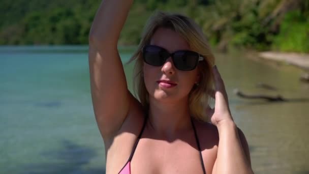 Jeune femme en maillot de bain rose à la plage — Video