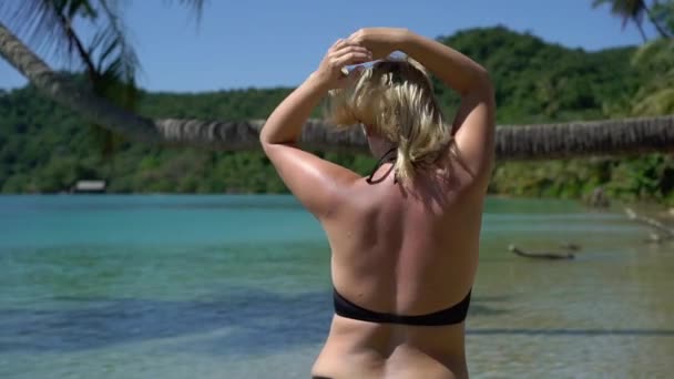 ビーチでピンクの水着の若い女性 — ストック動画