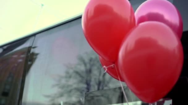 Rode ballonnen in de buurt van bus — Stockvideo