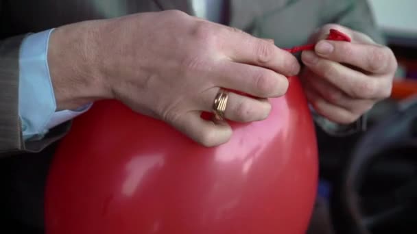 Man tieing red balloon — Stock Video