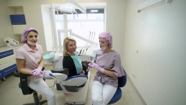 Пациент, зубной врач и ассистент в стоматологической клинике — стоковое видео