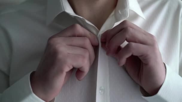 Hombre abotonando camisa blanca — Vídeos de Stock