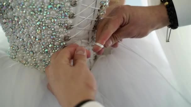 Mann bindet Spitze an Brautkleid — Stockvideo