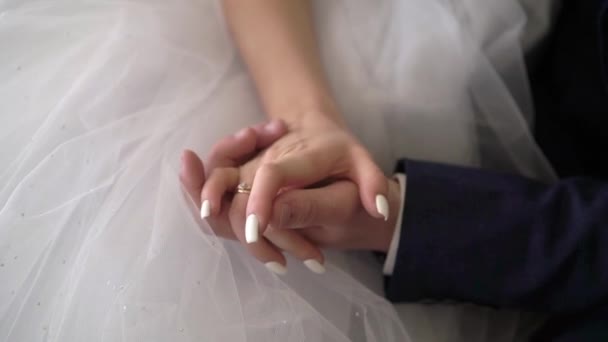 Brud og brudgom sitter og tar hverandre i hendene – stockvideo