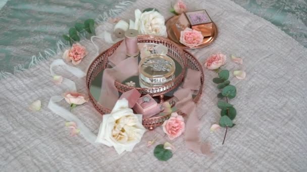 Bandeja rosa con pendientes nupciales anillo de propuesta y perfume — Vídeos de Stock