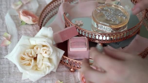 Femme mettre bague de bijoux dans une boîte à plateau rose avec bague de demande en mariage boucles d'oreilles et parfum — Video