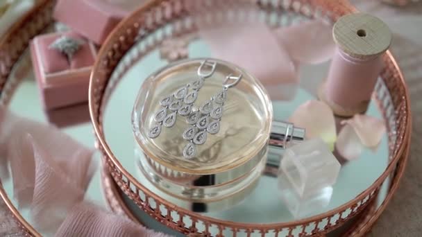 Pink tray with bridal earrings proposal ring and perfume — Stock Video