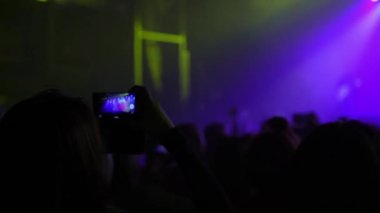 İnsanlar üstünde hareket eden telefon Atıcılık Kulübü, konserinde