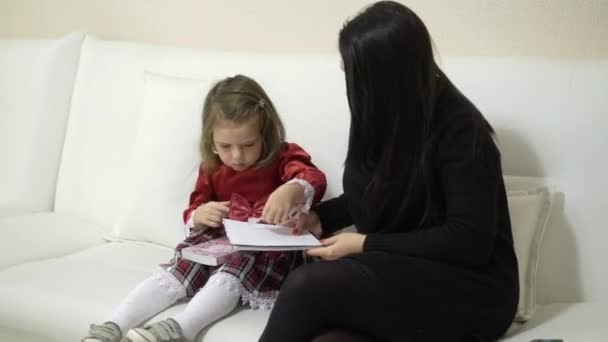 Matka a malou dcerou sledování knihy se samolepkami — Stock video