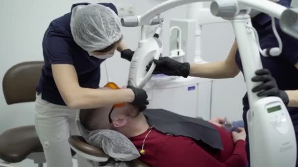 САИНТ-ПЕТЕРБУРГ, РОССИЯ - 21 МАРТА 2018 года: Стоматолог отбеливает зубы пациенту — стоковое видео