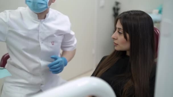 Médico dentista revisando los dientes del paciente — Vídeos de Stock