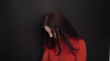 Gülümseyen ve siyah arka plan konuşan genç esmer kadın