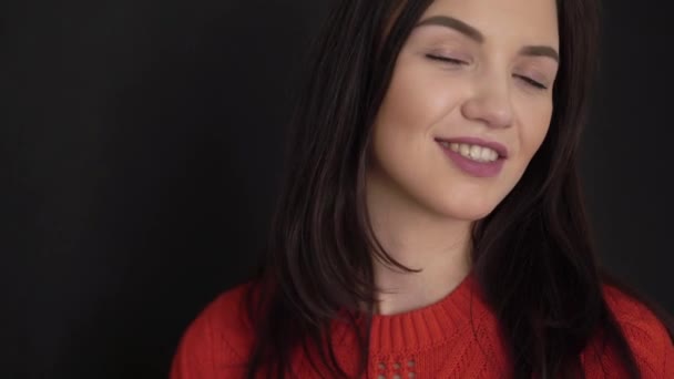 Mladá bruneta žena s úsměvem a mluví na černém pozadí — Stock video