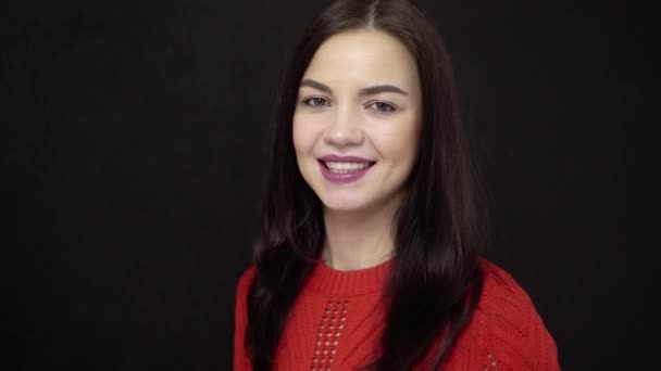 Joven morena sonriendo y hablando en el fondo negro — Vídeos de Stock