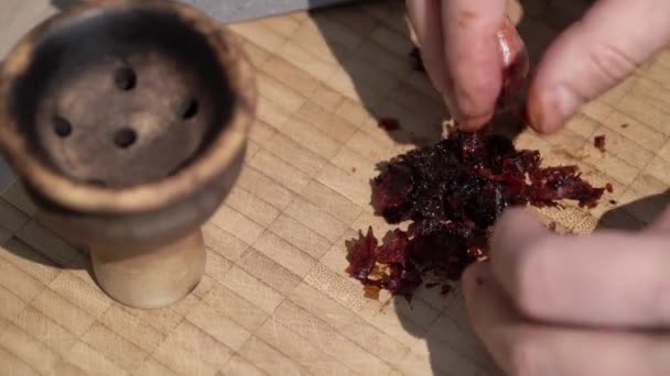 Человек готовит табак для кальяна — стоковое видео