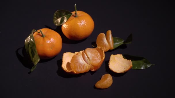 Dua jeruk mandarin dengan daun di latar belakang hitam — Stok Video