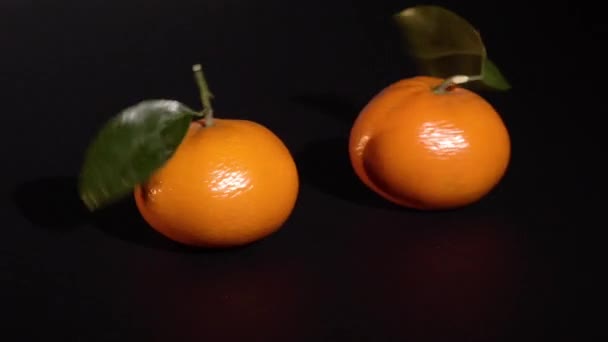 Citrus mandarin with leafes on black background — Stock Video