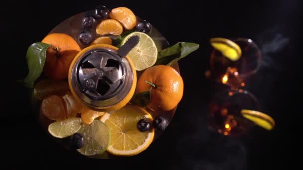 Sepasang gelas dengan minuman beralkohol anggur dan hookah dengan buah-buahan — Stok Video