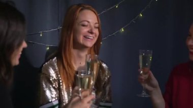 Noel ve Yeni Yıl kutlaması için hazırlık. Şenlik partisi, genç kadınlar kadehleri şampanya ile tokuşturur, eğlence. Kızlar köknar dallarından çelenk yapar. Tatil için tasarım atölyesi