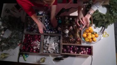 Noel ve Yeni Yıl kutlaması için hazırlık. Kızlar Noel ağacını toplar ve oyuncaklarla süslerler. Şenlik havası