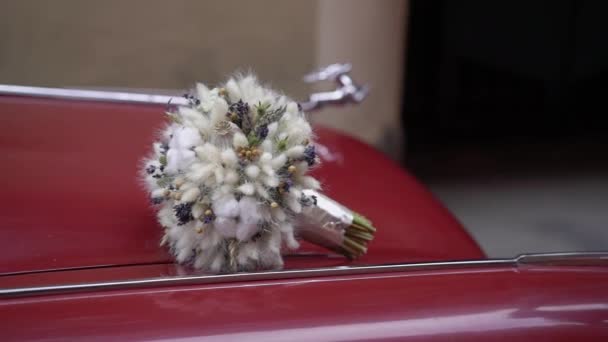 Αγία Πετρούπολη, Ρωσία - 15 Αυγούστου 2019: Παλιό ρετρό αυτοκίνητο στο δρόμο της πόλης. Κόκκινο Βόλγα 21 Ussr ρωσικό αυτοκίνητο. Νυφικό γαμήλιο μπουκέτο λουλούδια στο καπό. — Αρχείο Βίντεο