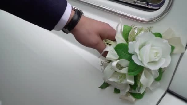 Bir adam düğün arabasının kapısını açar. Beyaz retro araba. Damat arabada oturur. — Stok video