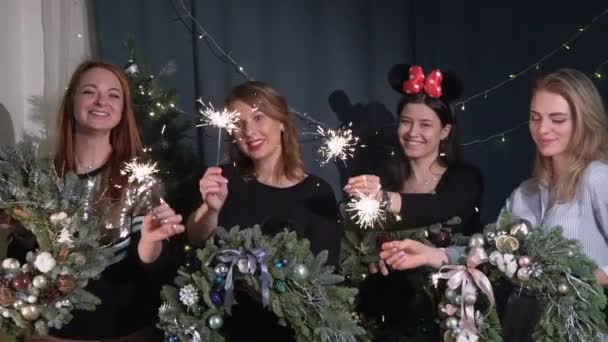 Preparación para la celebración de la Navidad y Año Nuevo. Chicas con corona de abeto decorado con pelotas y juguetes. Humor festivo — Vídeo de stock