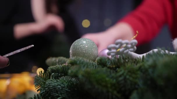 Προετοιμασία για τον εορτασμό των Χριστουγέννων και της Πρωτοχρονιάς. Τα κορίτσια στολίζουν το χριστουγεννιάτικο δέντρο με μπάλες και παιχνίδια. Γιορτινή διάθεση — Αρχείο Βίντεο