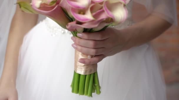 Fiatal menyasszony menyasszonyi ruhában csokorvirággal a kezében egy városban. Fehér luxus ruha divat — Stock videók
