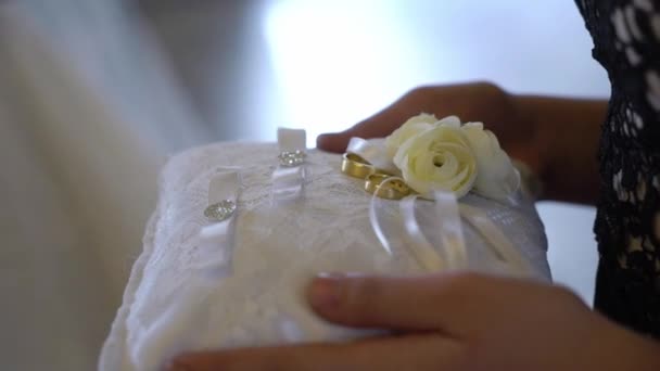 Inele de nuntă pe pernă. Nunta în Biserică. Ceremonia de căsătorie într-o biserică creștină. Preotul, mireasa şi mirele din interior . — Videoclip de stoc