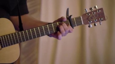 Gitarist konserde gitar çalıyor. Sahnede telli enstrümanlı müzisyen.