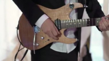 Gitarist konserde gitar çalıyor. Sahnede telli enstrümanlı müzisyen.