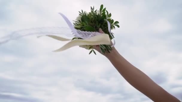 लग्नाच्या ड्रेसमधील तरुण वधू उद्यानात पुष्पगुच्छ फुले धारण करतात. व्हाइट लक्झरी गॅव्हन फॅशन — स्टॉक व्हिडिओ