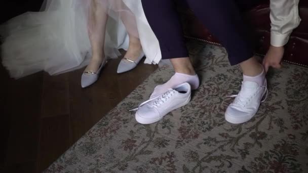 Young bride put on shoes on heels. Woman fashion white shoes for wedding day — Stock Video