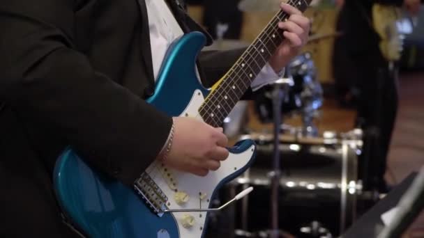 Гитарист играет на гитаре на концерте. Музыкант со струнным инструментом на сцене . — стоковое видео