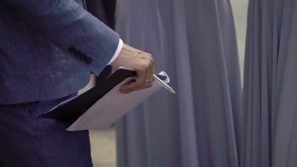 Affärsman i blå kostym innehav mapp med papper eller dokument i händerna — Stockvideo