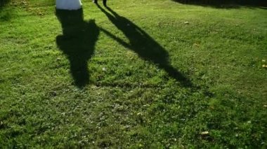 Güzel çift gölgesi. İnsanlar yaz günü dışarı çıkıyorlar. Gelin ve damadın silueti sarılıyor