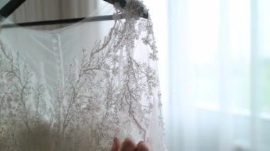 Nedime, genç gelinin gelinliğini giymesine yardım ediyor. Lüks gelinlik.