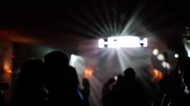 Gente bailando en la fiesta. Silueta irreconocible multitud en discoteca con luz disco — Vídeo de stock