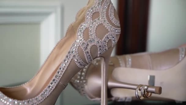 Wedding rings and bridal shoes. Pair of marriage symbols. Love of bride and groom becoming wife and husband. Matrimony symbol. — Stock Video