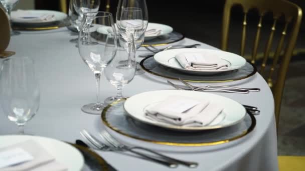 Vasos, platos, cubiertos y servilletas. Mesas decoradas con flores para la fiesta. Recepción de la boda, cumpleaños, aniversario. — Vídeo de stock