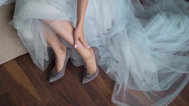A jovem noiva calça sapatos nos saltos altos. Mulher moda sapatos brancos para o dia do casamento — Vídeo de Stock