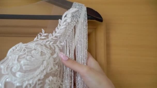 Brudtärna hjälper unga bruden att ta på sig sin bröllopsklänning. Lyxig brudklänning — Stockvideo