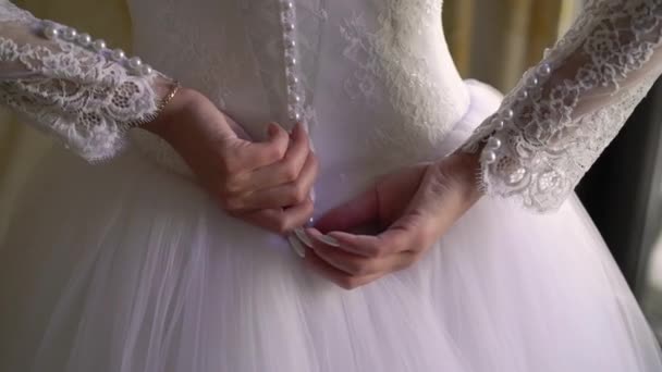 Bridesmaid helping for young bride to put on her wedding dress. Luxury bridal gown — Stock Video