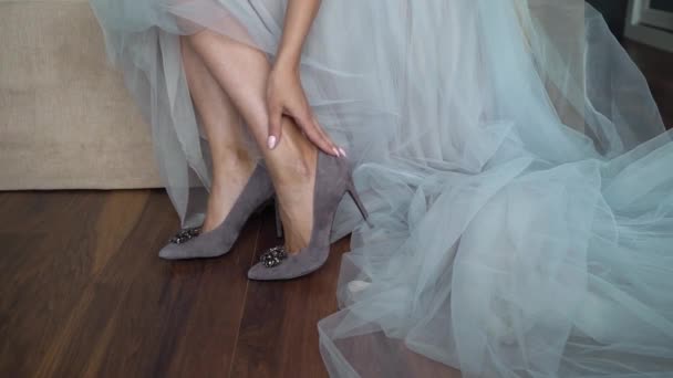 Young bride put on shoes on heels. Woman fashion white shoes for wedding day — Stock Video