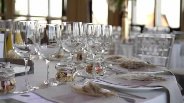 Vasos, platos, cubiertos y servilletas. Mesas decoradas con flores para la fiesta. Recepción de la boda, cumpleaños, aniversario. — Vídeos de Stock