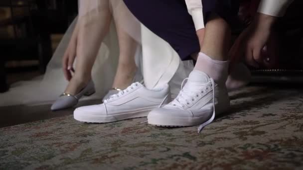 Young bride put on shoes on heels. Woman fashion white shoes for wedding day — Stock Video